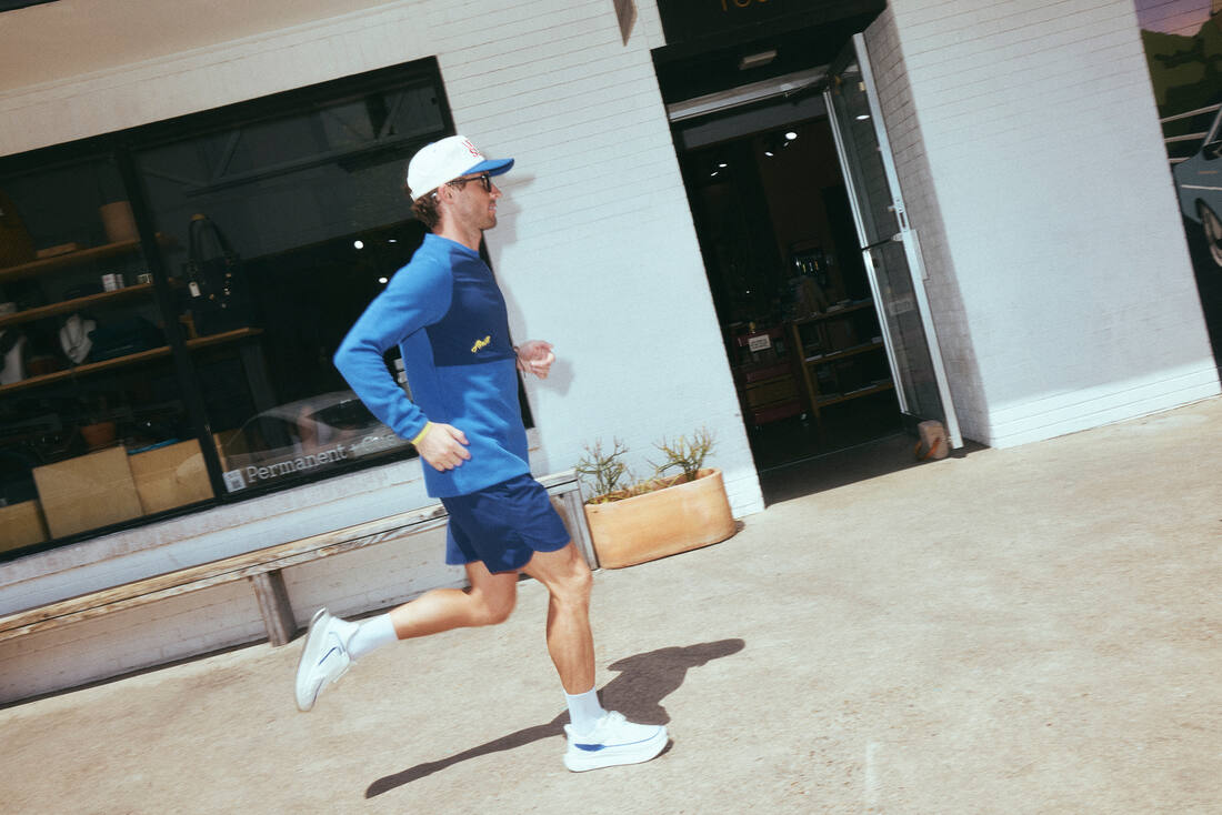 Runner wearing the blue Ramble outside a storefront